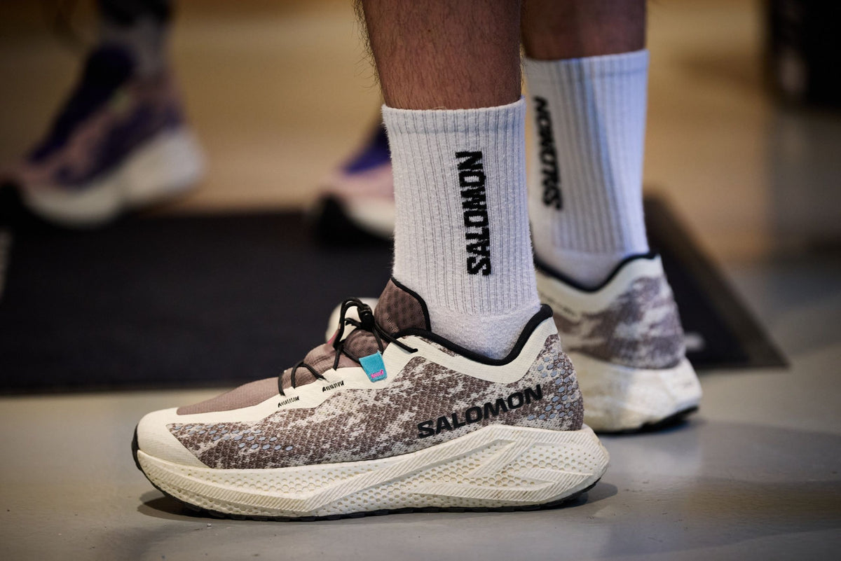 Salomon running shoe and Salomon socks on a store floor