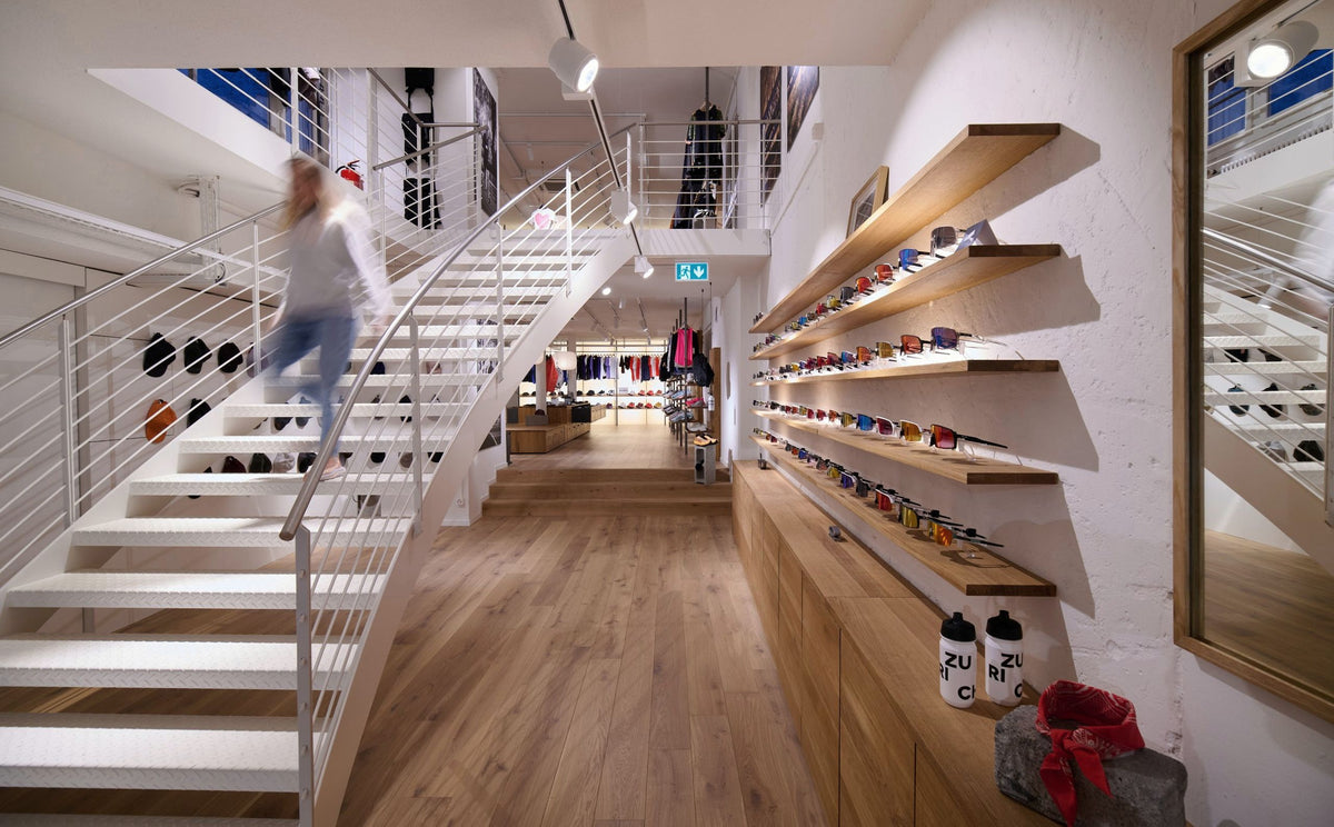 Run Store Zurich interior with white staircase, shoe wall and sunglasses shelves